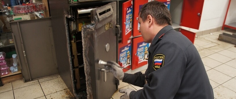 сотрудник МВД снимает отпечатки пальцев с сейфа