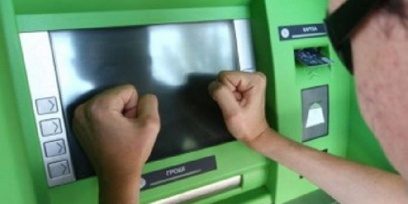 человек, бьющий кулаками по банкомату