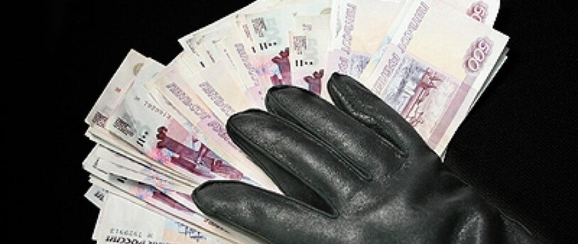 рука в черной перчатке лежит на пачке банкнот