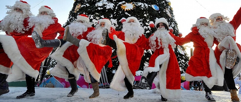 танцующие люди в костюмах Деда Мороза