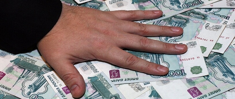 рука преступника лежит на раскиданных тысячных банкнотах