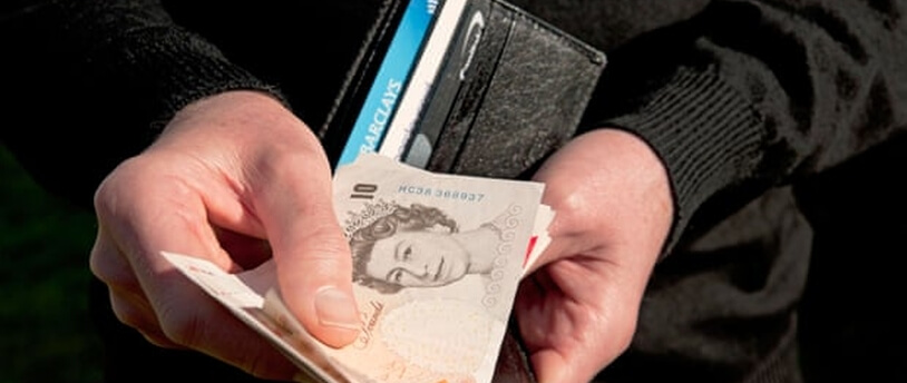 человек держит кошелек с британскими фунтами