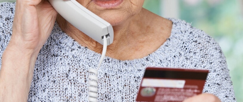 пожилая женщина сообщает по телефону данные с банковской карты