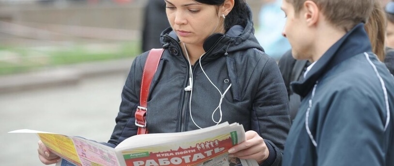 люди, читающие газету по поиску работы