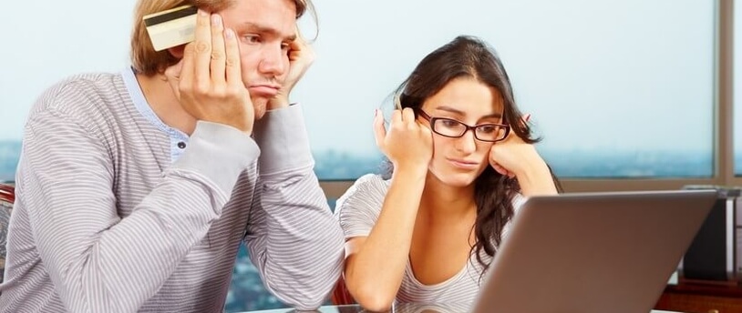 расстроенная молодая пара за компьютером