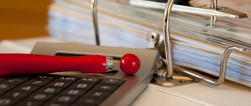 бумаги, калькулятор и ручка на столе