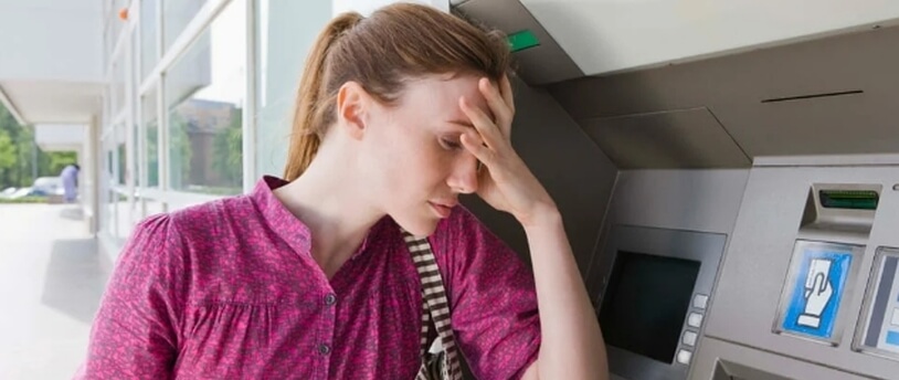 расстроенная женщина возле банкомата