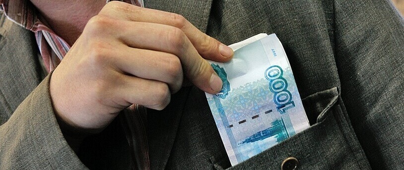 мужчина кладет деньги в карман пиджака