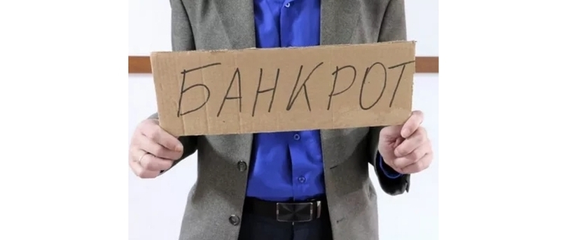 человек держит табличку с надписью "Банкрот"