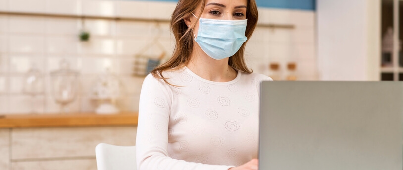 девушка в медицинской маске за компьютером