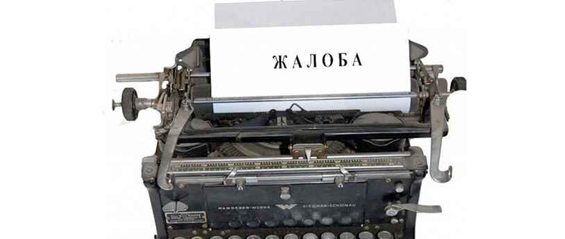 печатная машинка со вставленным в нее листом с надписью "жалоба"