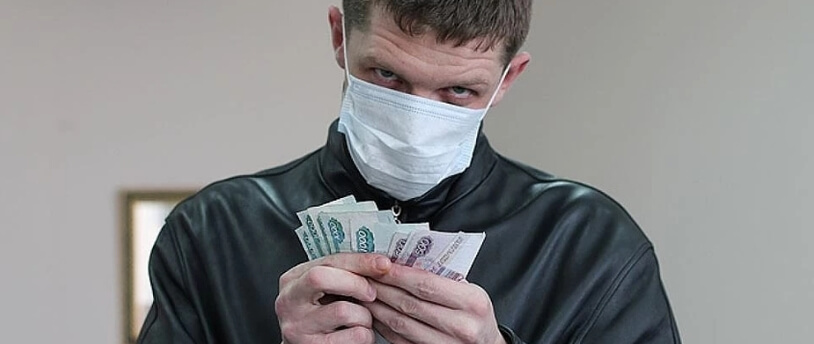 человек в маске с деньгами в руках