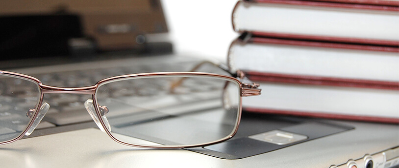 очки и книги на фоне ноутбука
