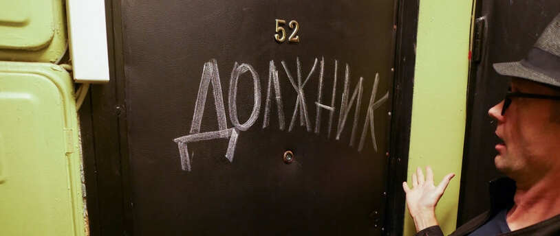 надпись на входной двери "Должник"