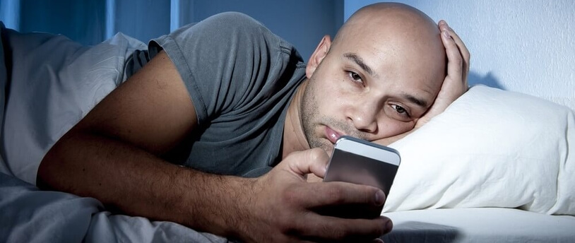 человек в постели с телефоном